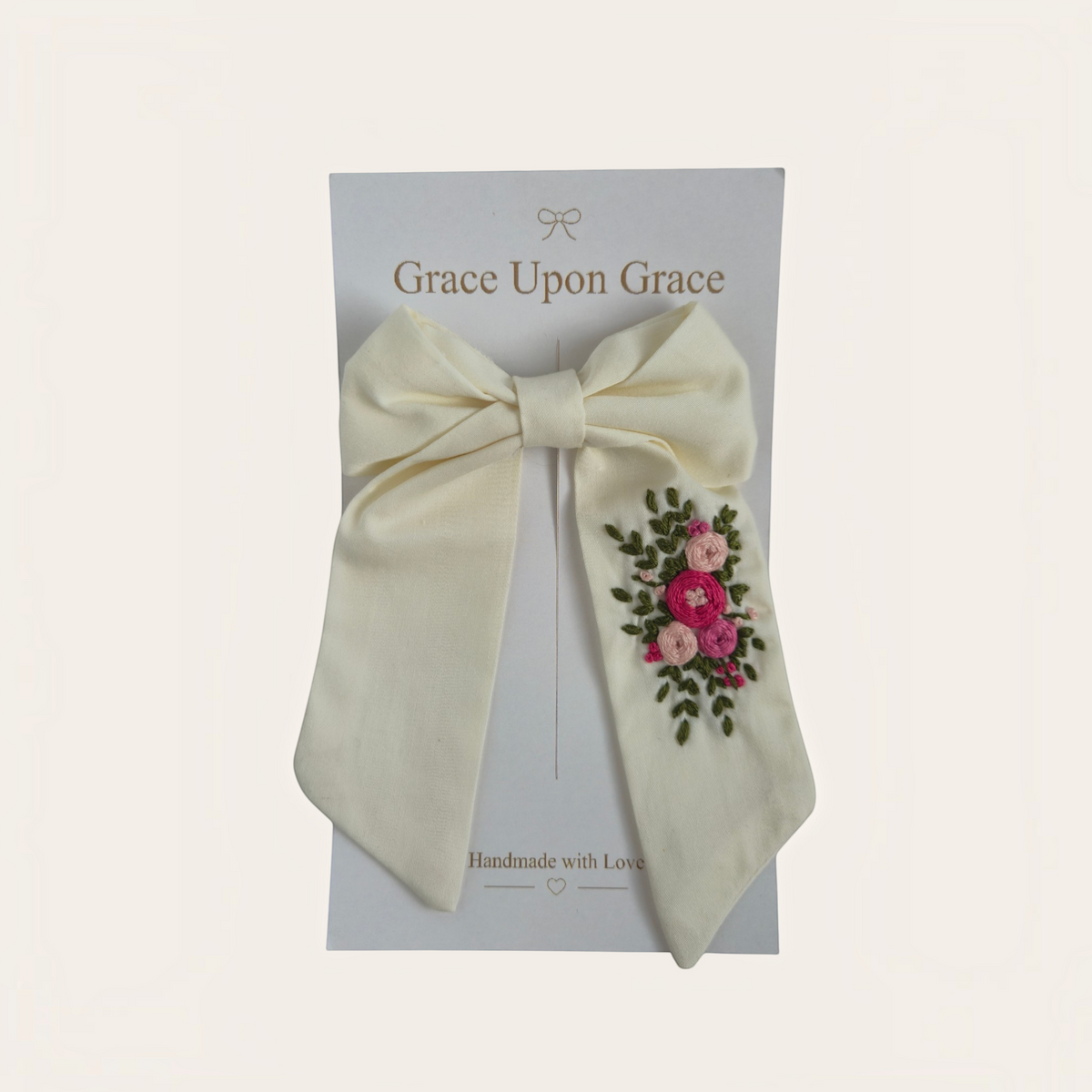 Grace Upon Grace ivory sailor bow featuring hand-embroidered pink bullion roses and green leaves on a hair clip.