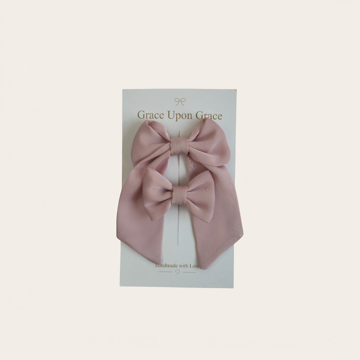 Grace Upon Grace dusty rose satin hair bow duo featuring one mini bow and one long-tailed sailor bow on clips.